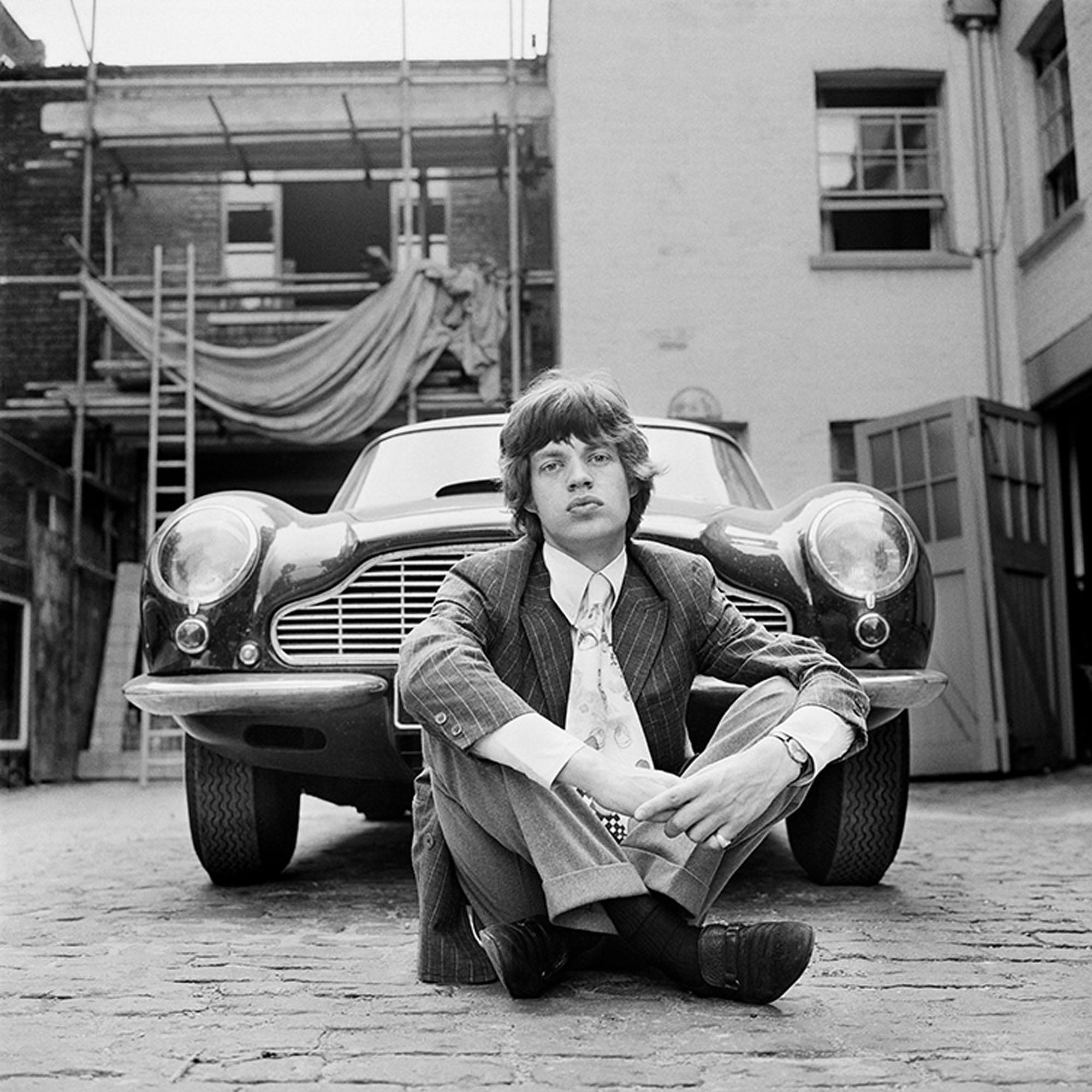 Mick Jagger photographed next to an Aston Martin DB6 car in London, 1966. Gered Mankowitz