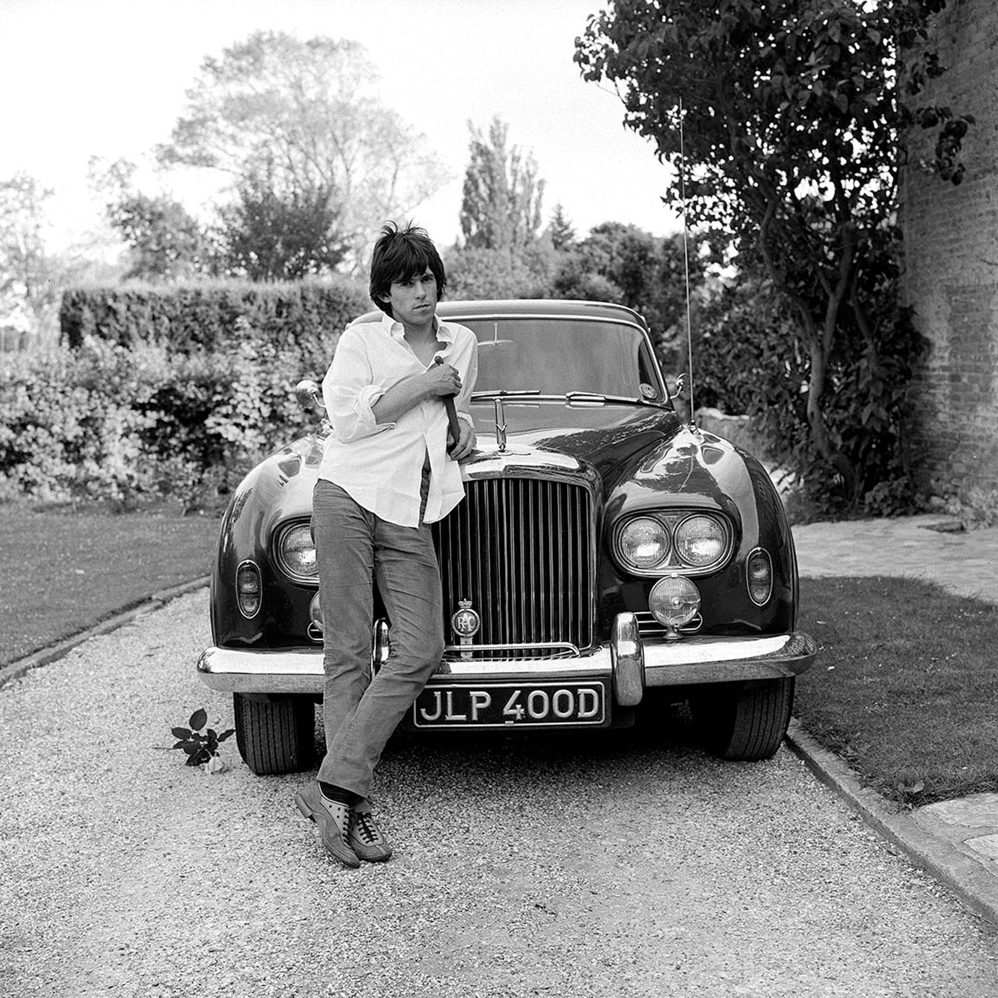 Keith Richards photographed next to a Bentley 'Blue Lena' in West Sussex, 1966.